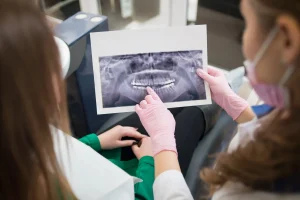 Ortodoncista explica radiografía a paciente con enanismo radicular